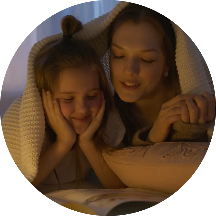 Mother and Daughter Lying on Bed while Reading a Book