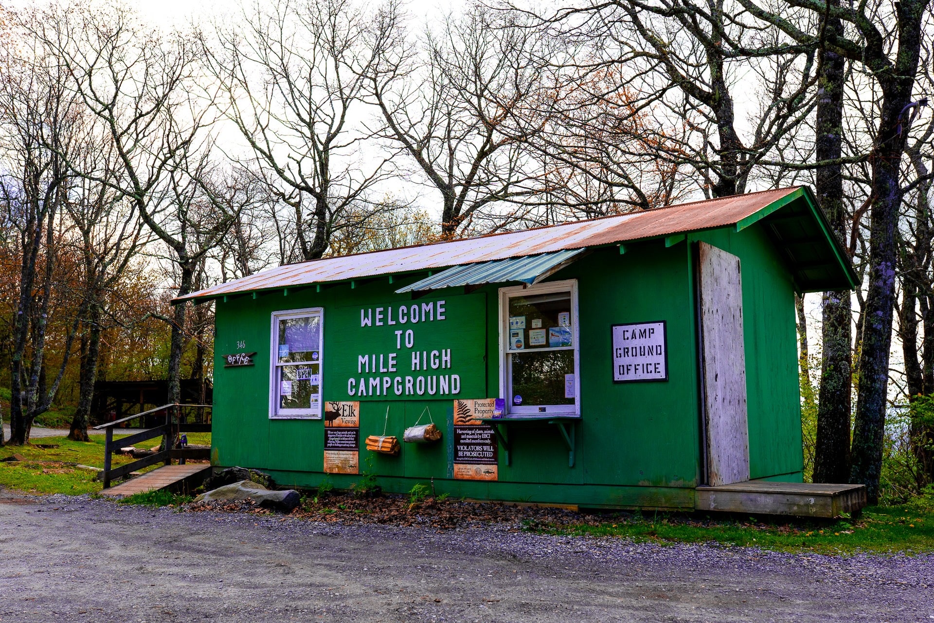 Scenic view of a green building with white lettering at Mile High Campground, nestled in the Great Smoky Mountains.