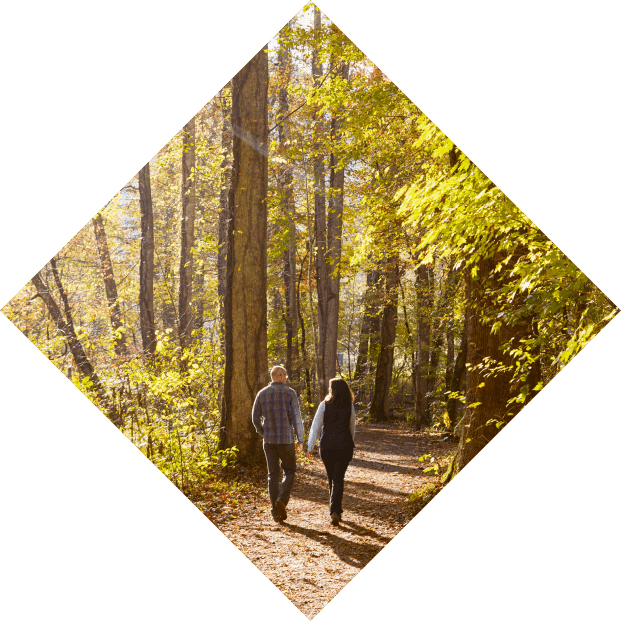 A middle-aged couple, walking together on a forest trail