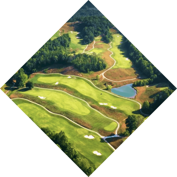 Aerial view of the vibrant Sequoyah National Golf Course with various shades of green and orange autumn trees surrounding the neatly manicured fairways and greens.