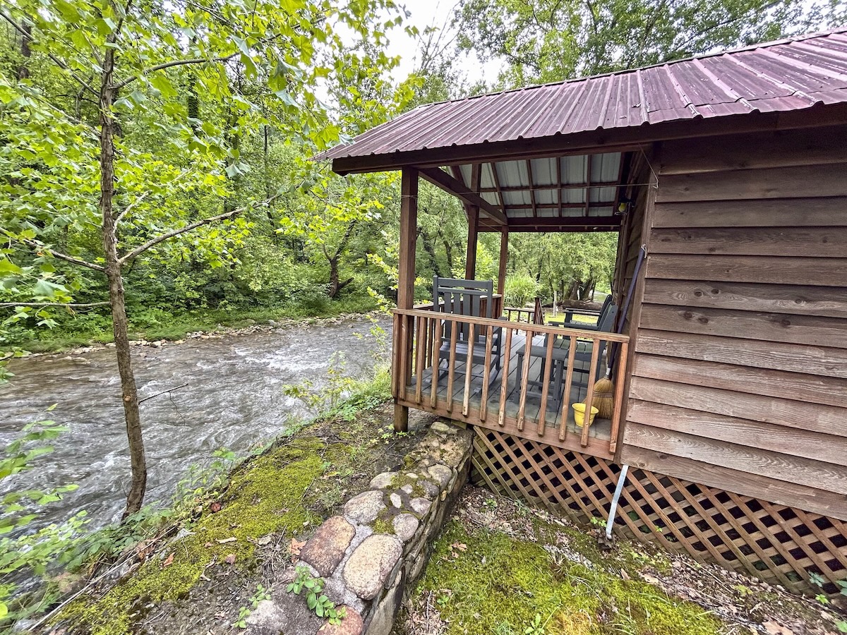 A cabin at Lazy Turtle Campground and Cabins next to a flowing river.
